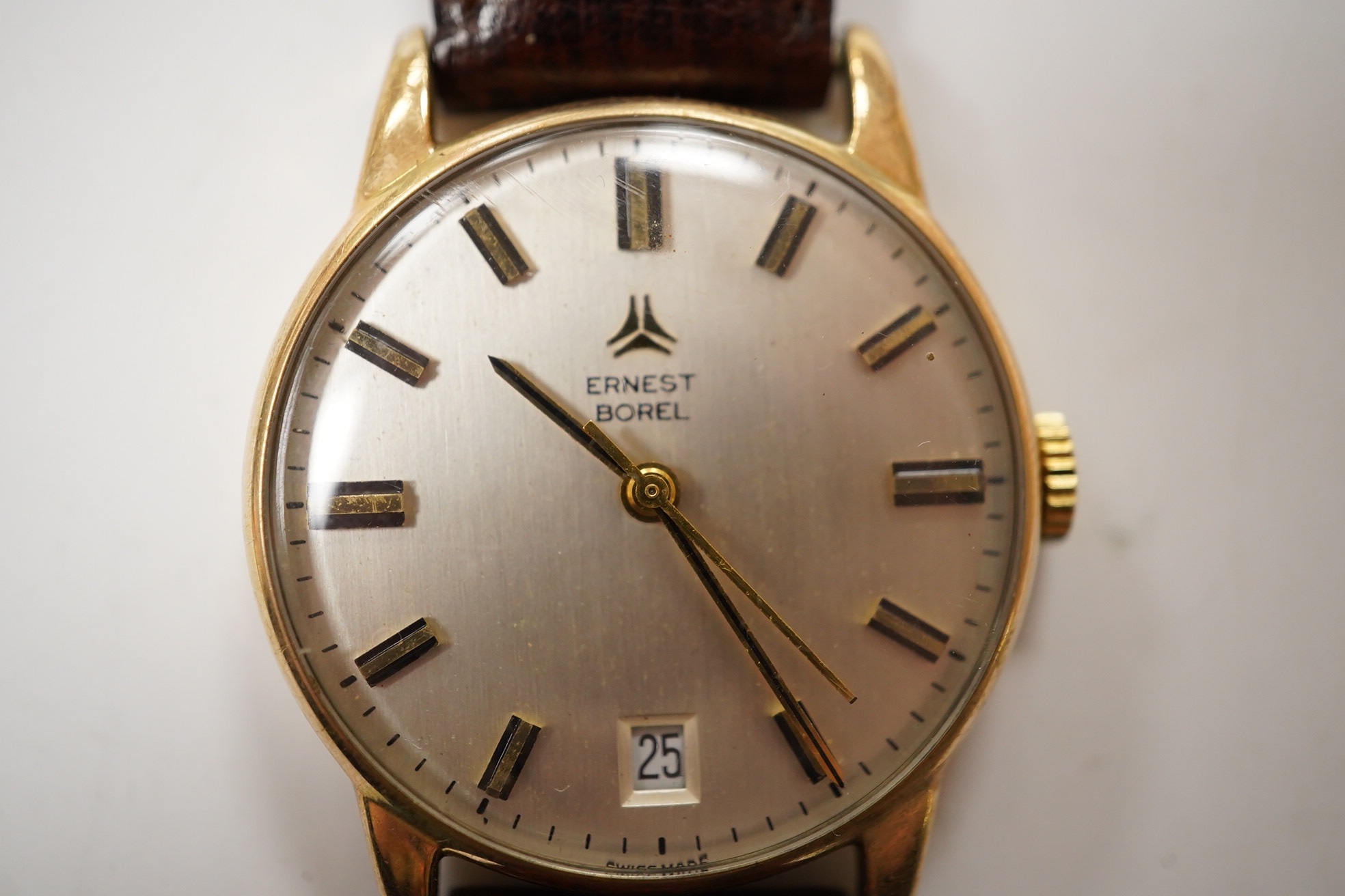 A gentleman's 9ct gold Ernest Borel manual wind wrist watch, with baton numerals and date aperture, case diameter 31mm, on a leather strap. Condition - fair